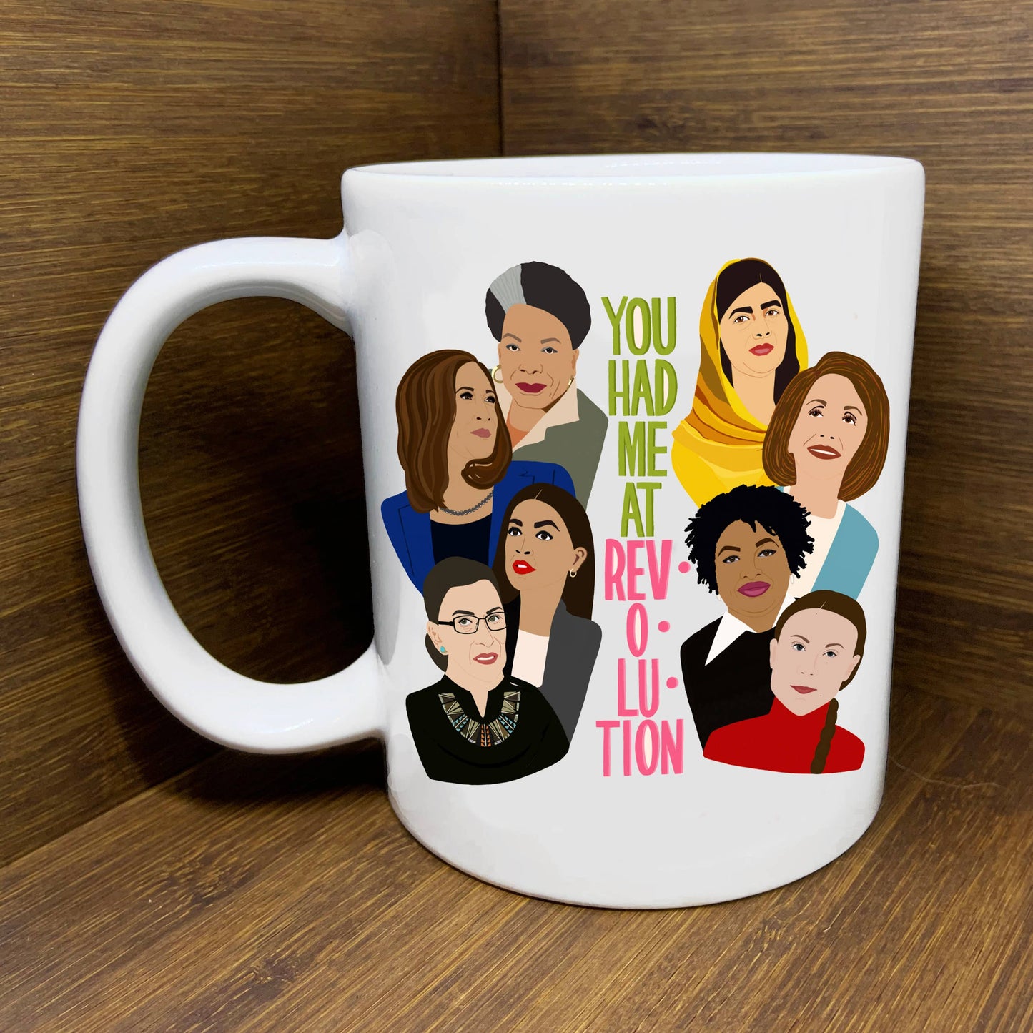 You Had Me Att Revolution Mug with images of 8 inspiring women shown on a wooden surface