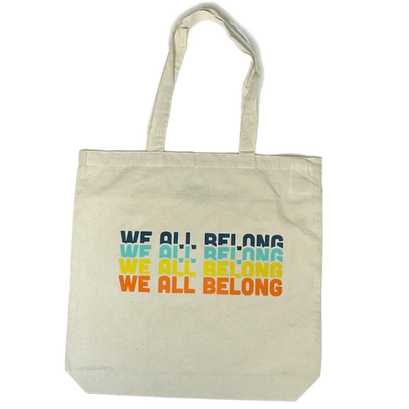 Canvas tote bag that states we all belong in bright colors.
