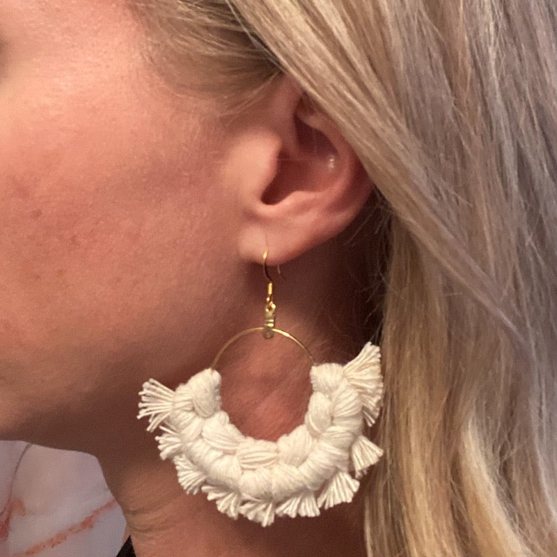 Cream macramé earrings on model
