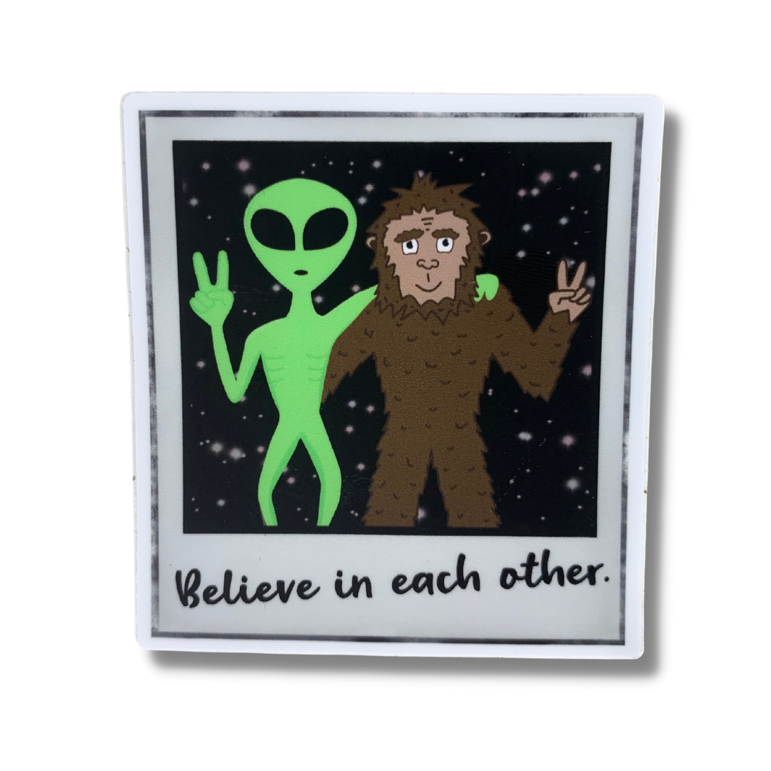alien and bigfoot sasquatch hugging and giving peace signs polaroid photo with believe in each other written beneath high quality premium vinyl sticker decal