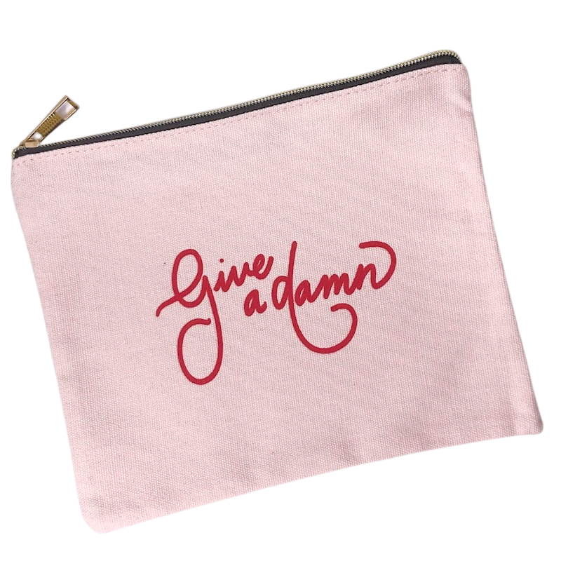 give a damn zipper pouch light pink canvas zipper pouch with cursive give a damn written on top in red