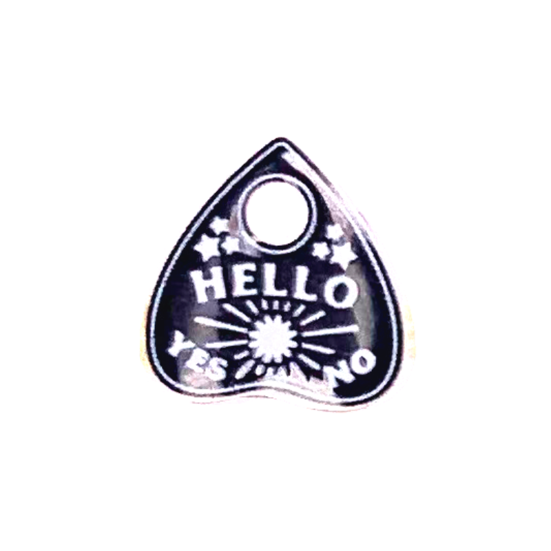 ouija board planchette stud earring close up the planchette is black and white and says hello and has yes no at the bottom