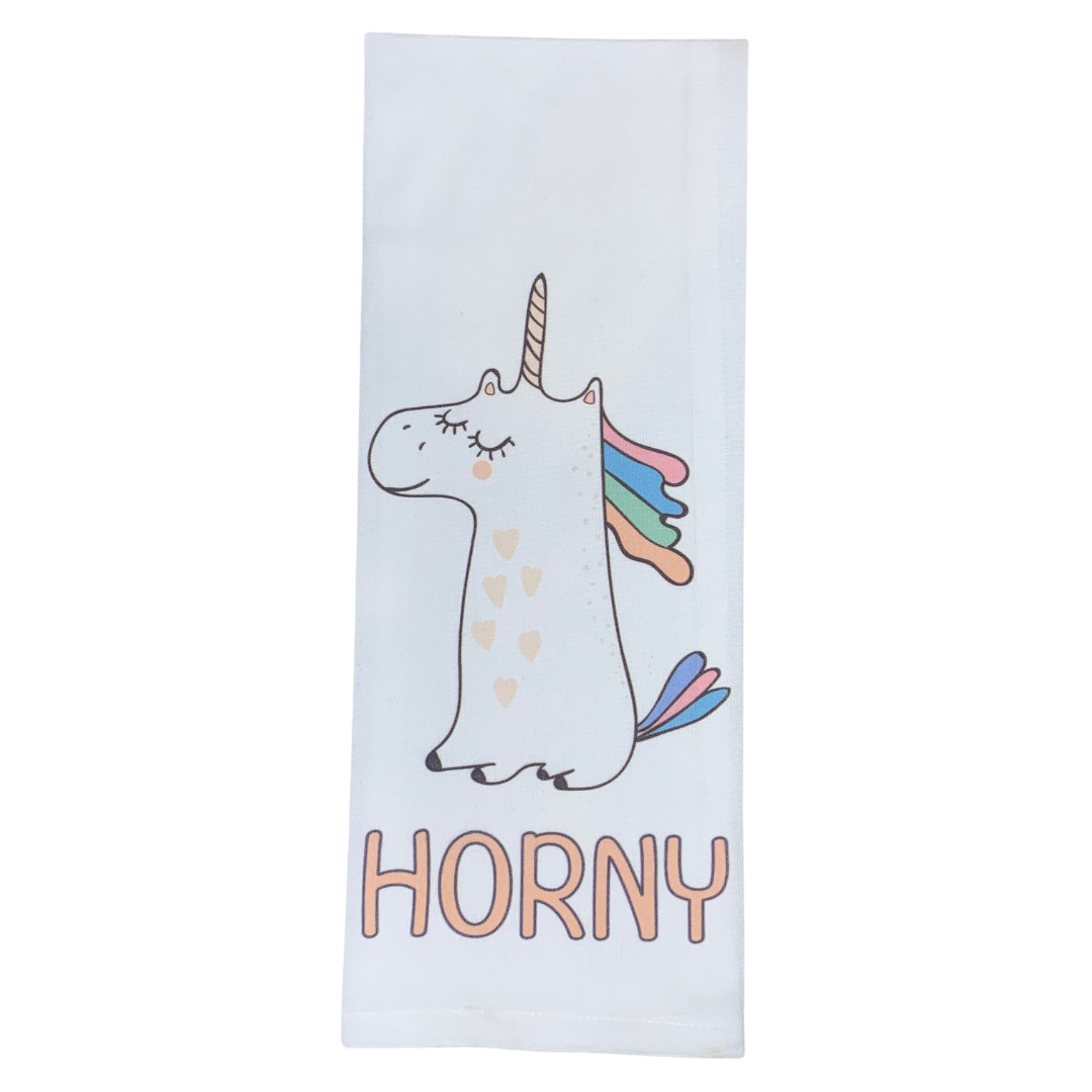 premium quality pre-shrunk hand kitchen towel that is white with a sitting unicorn on the front that is white with rainbow hair and tail and the towel says Horny at the bottom