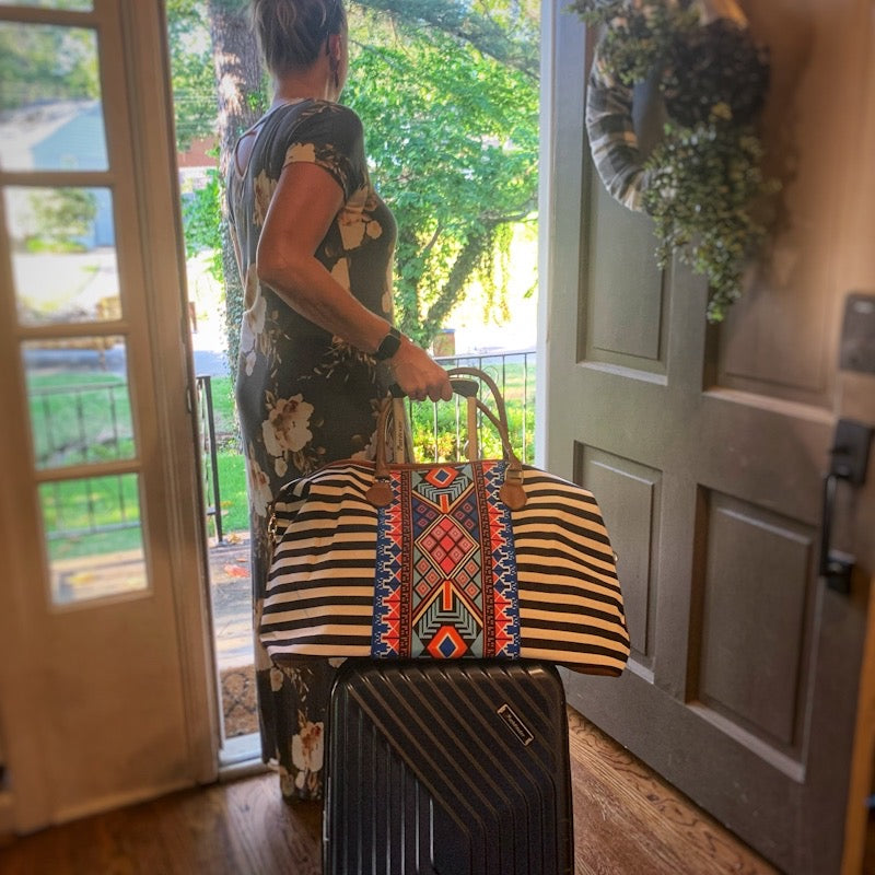 striped aztec weekender bag on suitcase